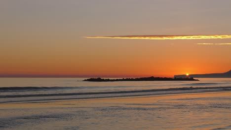 Coastal-sunrise-over-headland-with-calm-seas-and-gentle-waves,-mediterranean,-spain