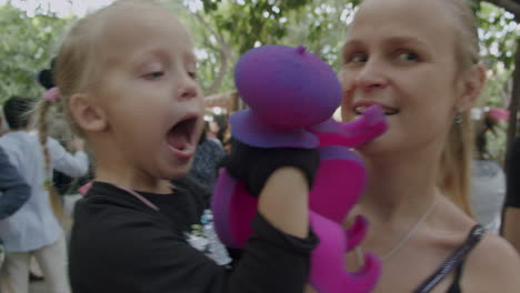 niño feliz divertido jugando con juguete y mamá durante un paseo por la ciudad