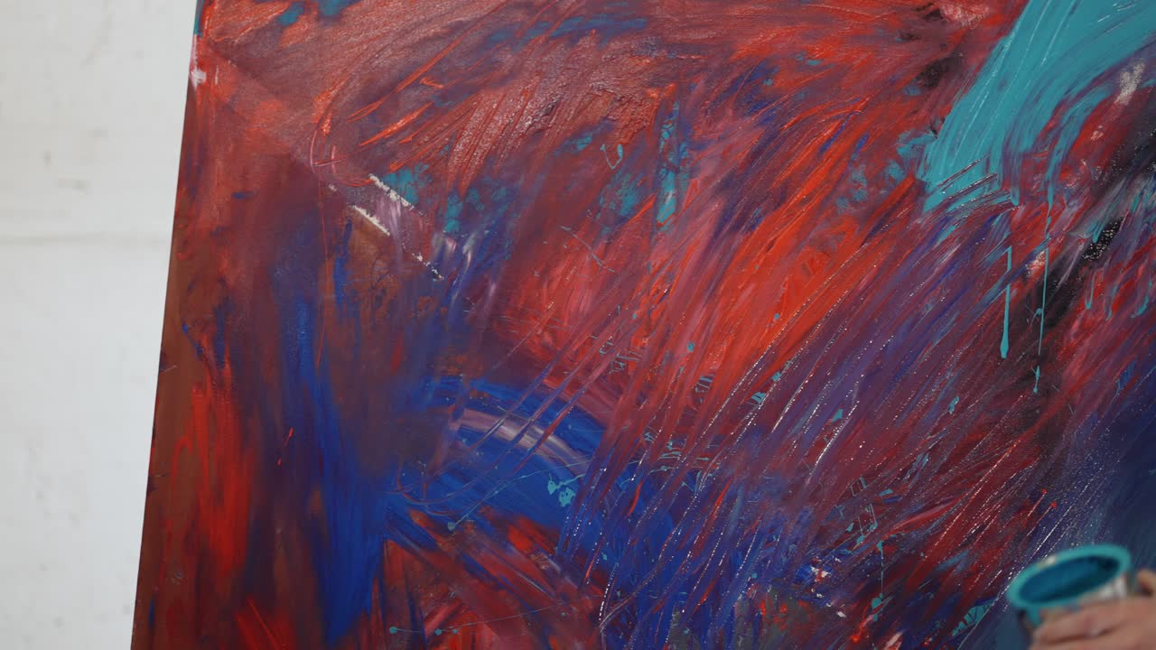 hombres y mujeres pintores trabajando juntos en un estudio de arte en un lienzo grande usando las manos