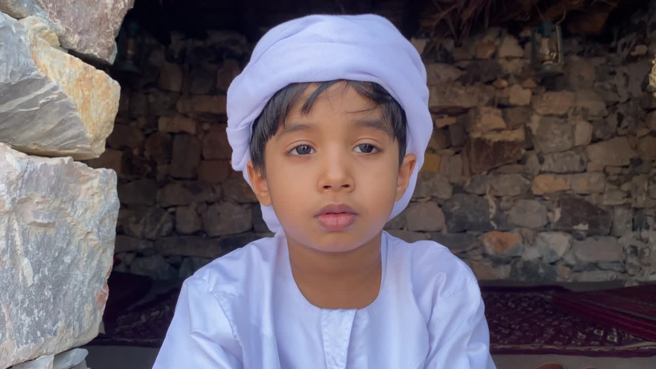 Anak Arab di rumah tradisional Arab yang terbuat dari batu