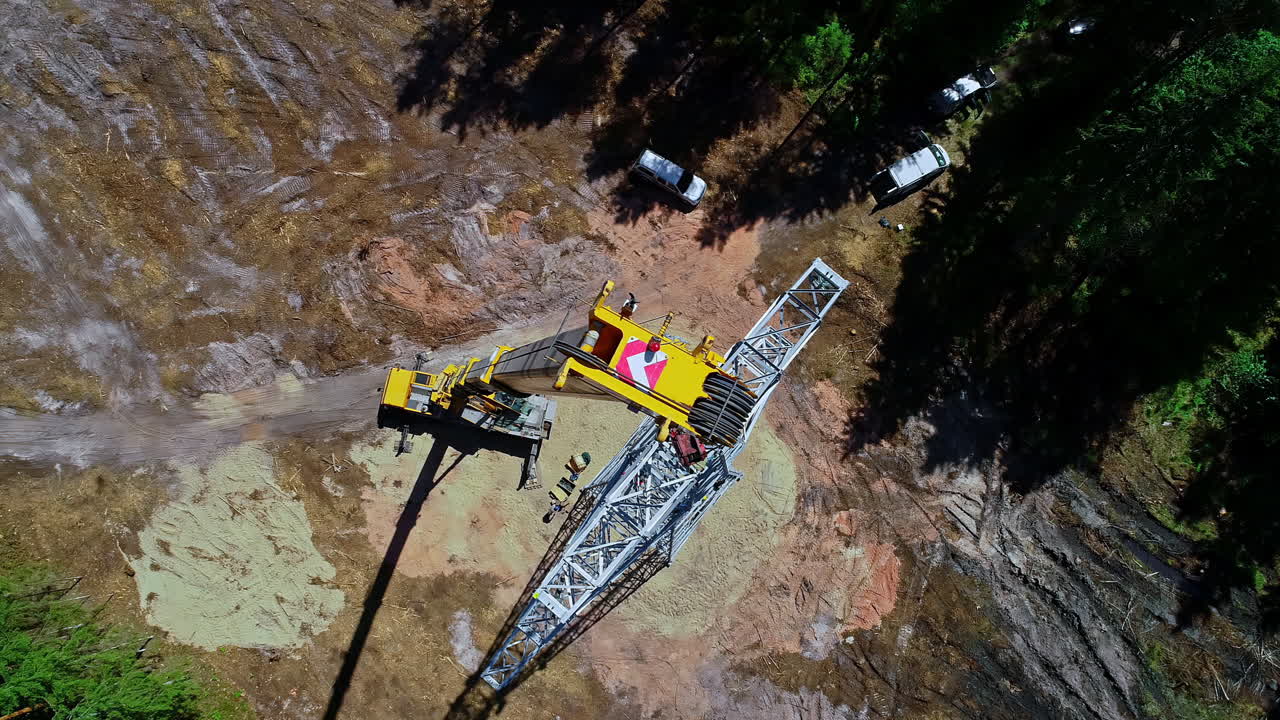 grúa móvil levanta el marco de acero de la torre de transmisión en el sitio de construcción