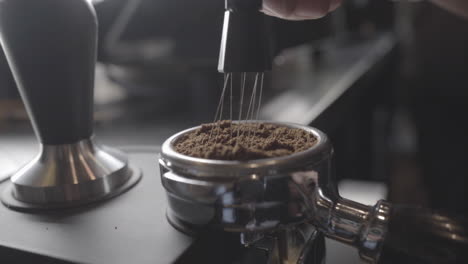 A-Reveal-Shot-Of-Ground-Coffee-Being-Stirred-With-A-Needle-Tamper-In-A-Portafilter