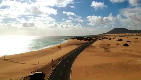 desertic road crossed by a car at the coast of fuerteventura