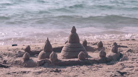 Castillo-De-Arena-En-La-Playa-Del-Océano-Amarillo-Contra-Olas-Espumosas