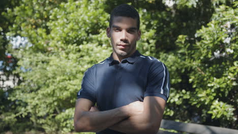 man with crossed arms looking at camera, being serious