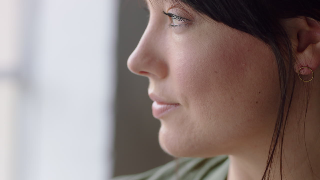 retrato hermosa mujer caucásica mirando por la ventana planeando hacia adelante sonriendo disfrutando de un estilo de vida exitoso visión relajante feliz en casa de cerca