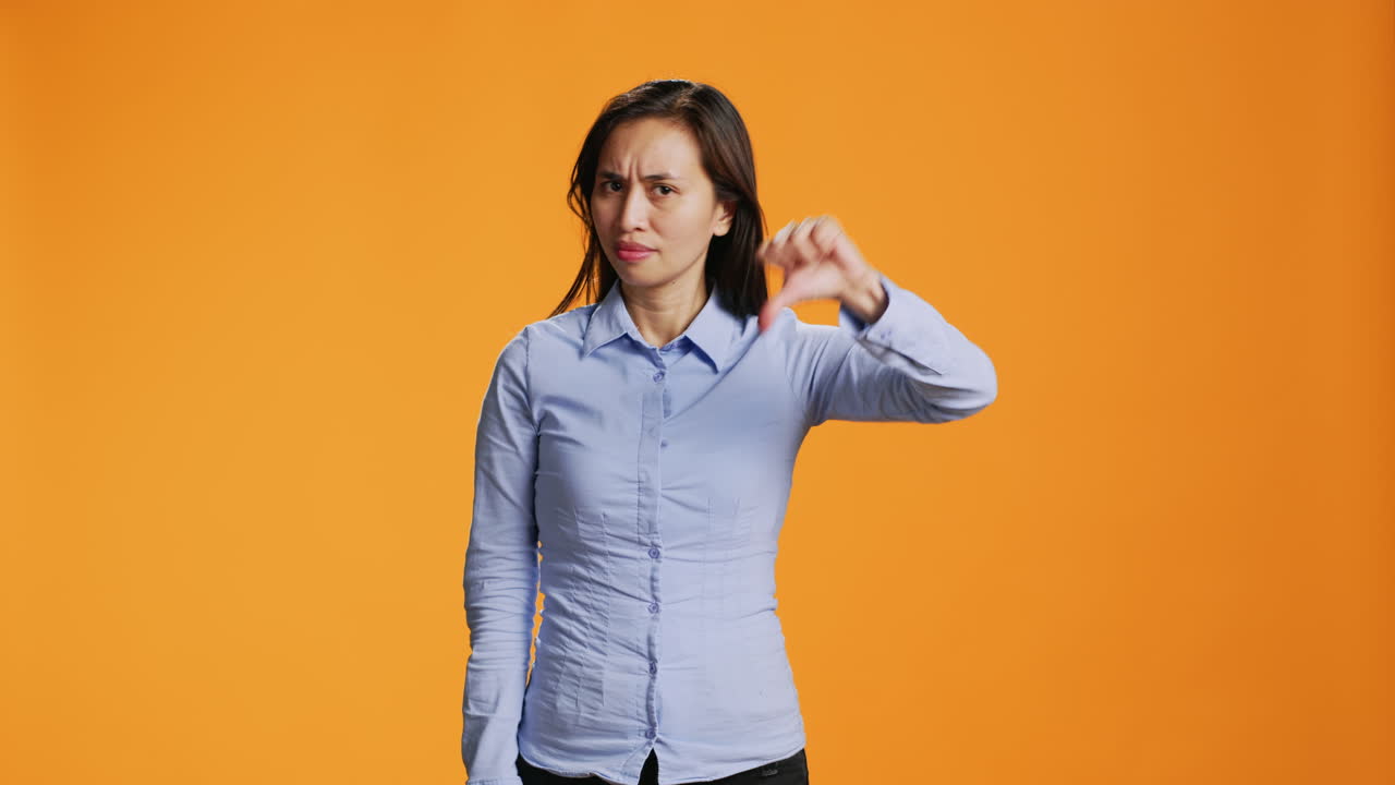 modelo asiático mostrando el símbolo de disgusto en el estudio