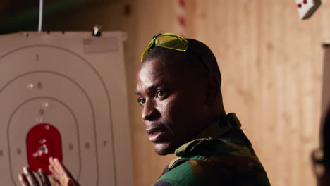 army leader teaches recruits in shooting gallery how to shoot target center