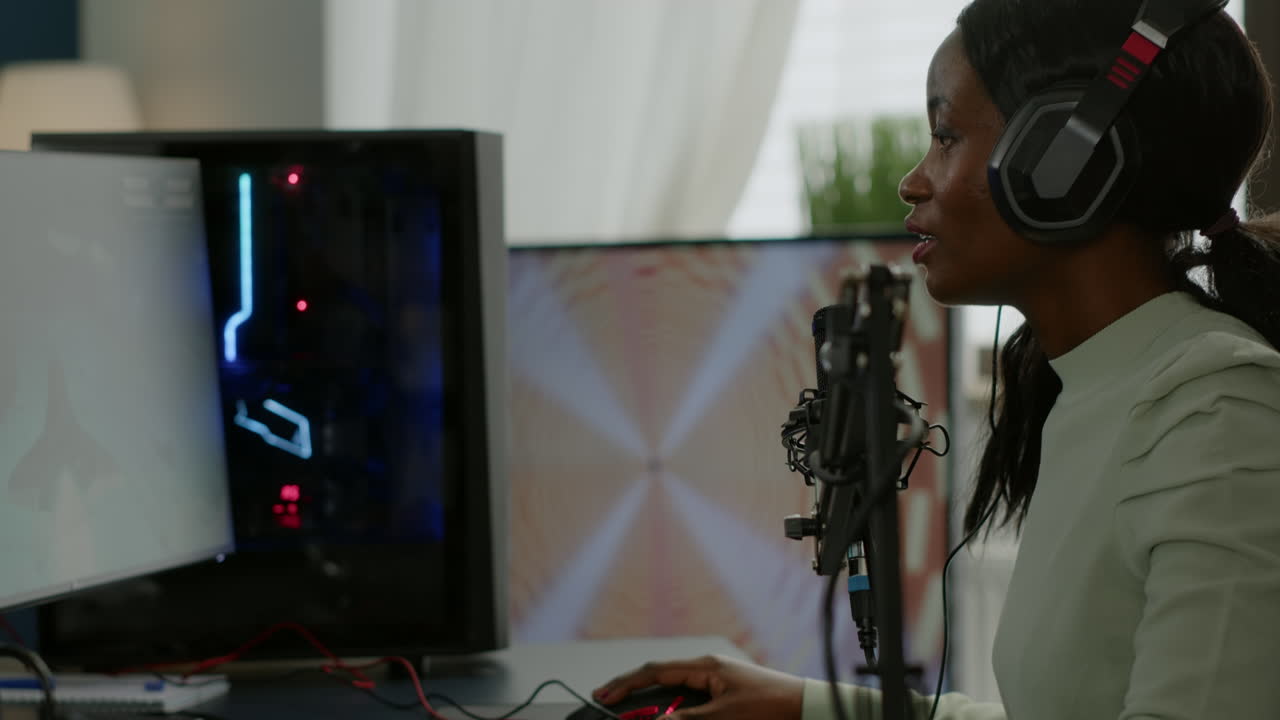 African gamer checking sound mixer sitting in gaming room