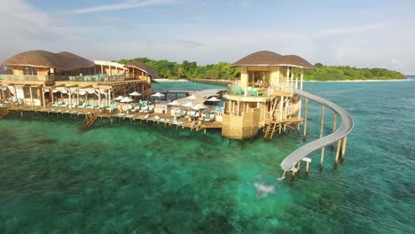 a woman goes down a water slide at an island resort in maldives