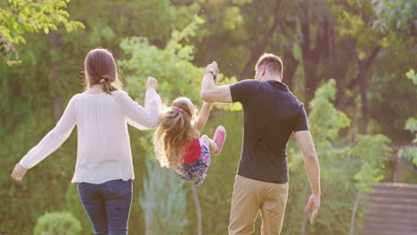 familia feliz caminando en el parque sosteniendo