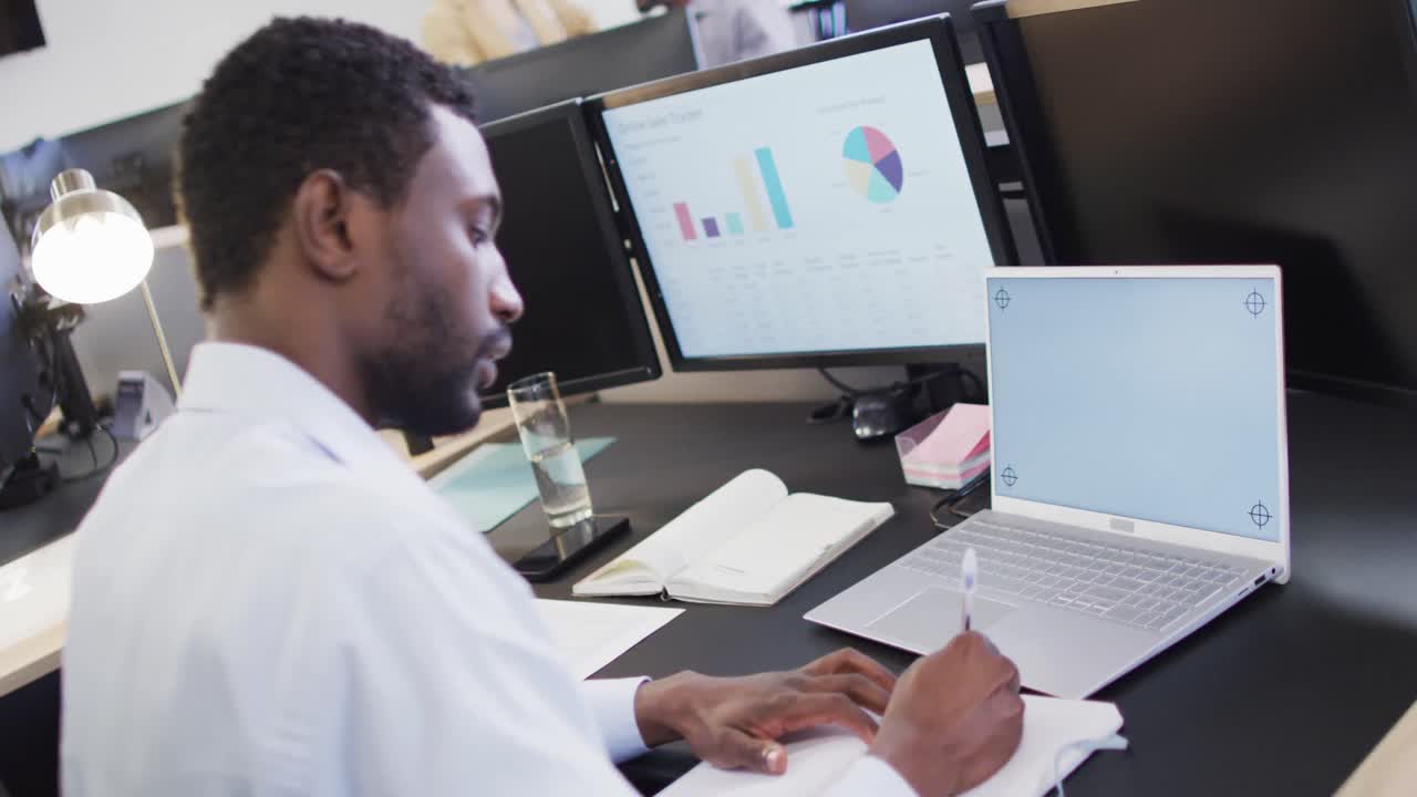 African american businessman using laptop with copy space in office, slow motion