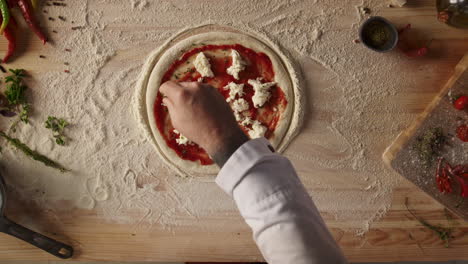 man making homemade pizza pepperoni italian food dinner on kitchen table board.