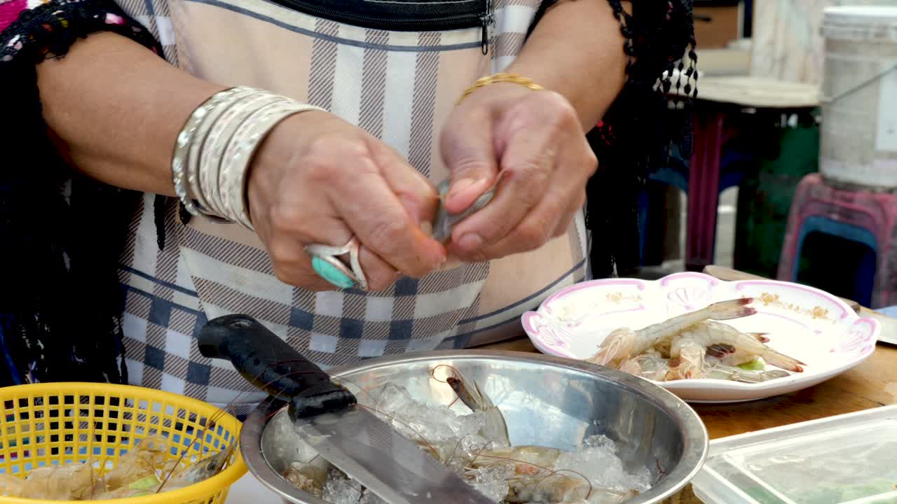 야외 주방에서 새우를 껍질을 벗기고 준비하는 늙은 손 - 클로즈업