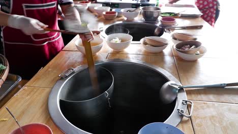 chef preparing noodles in a traditional kitchen