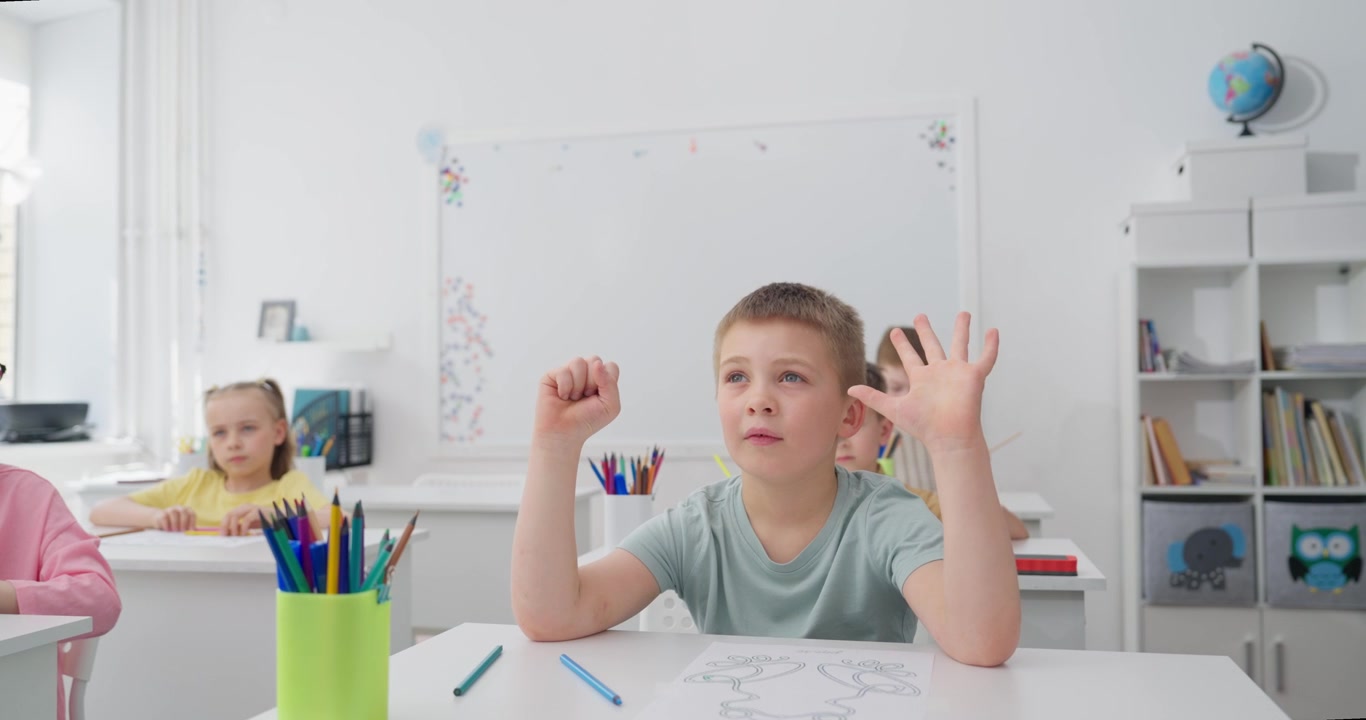 Young Boy Counting on Fingers in a Bright Classroom