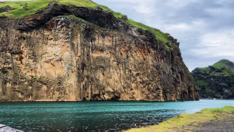 Lebhafte-Türkisfarbene-Klippe-Von-Heimaklettur,-Idyllische,-Abgeschiedene-Isländische-Bergbucht