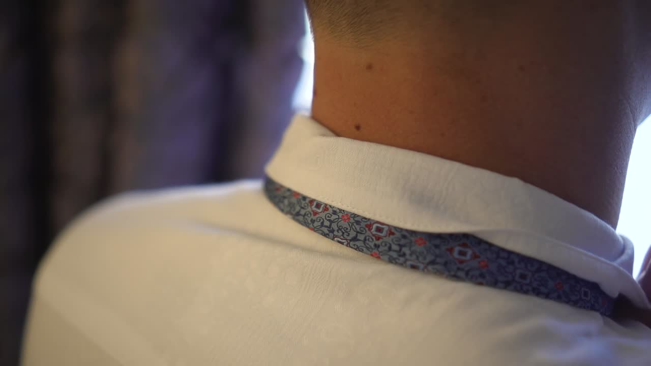 el hombre ajusta el cuello blanco y la corbata 02