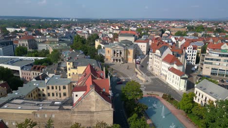 fountains are cascading in front of the opera house on a sunny day in halle saale, germany. drone shot footage from above