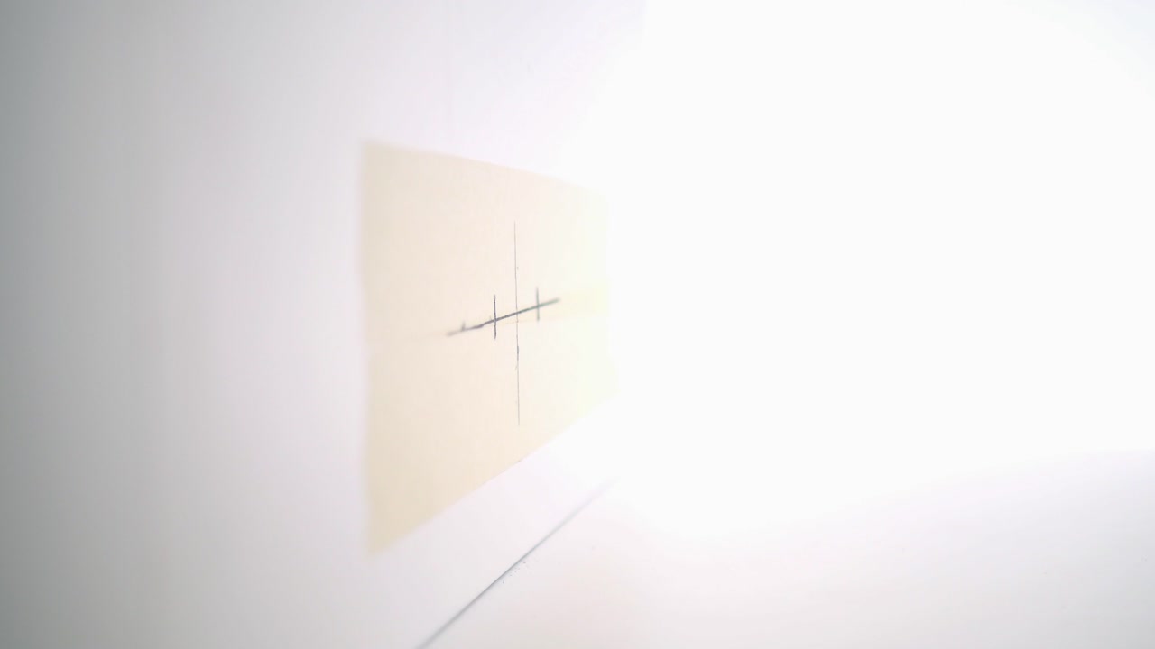 펜과 측정 테이프로 벽을 측정하고 표시하는 사람