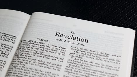 close up shot of bible page turning to the book of the revelation