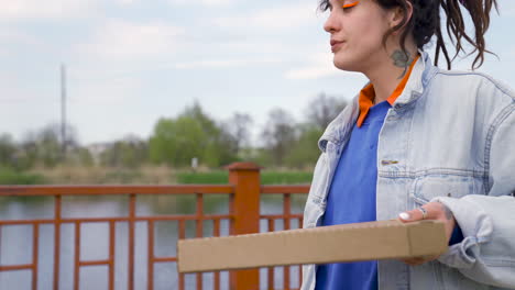 Two-Girl-Friends-Drinking-Beer-And-Walking-On-A-Bridge-While-Talking-Between-Them