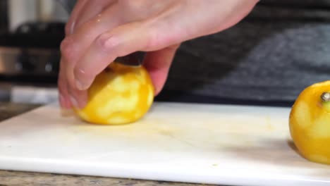 slow motion anonymous female hands slicing lemon citrus fruits closeup