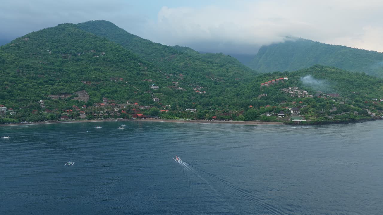 Beautiful panoramic view of amed village on the coast of bali, indonesia. Traditional jukung fishing boats sailing on the blue sea near a tropical beach