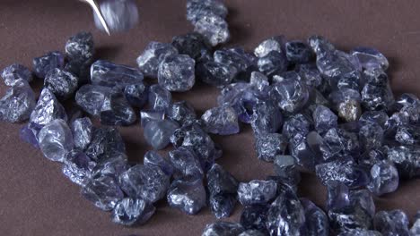 a gemologist examining and sorting rare ilolite gems, close up