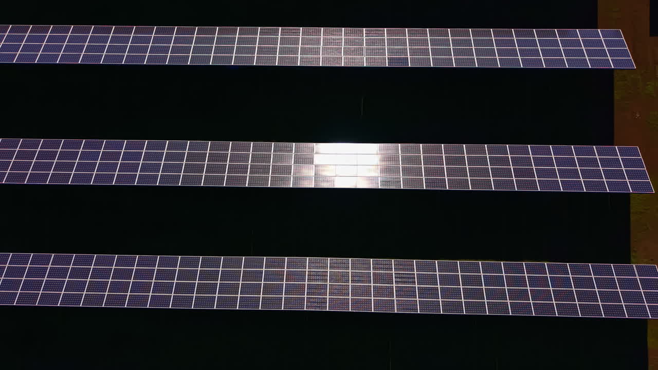 Pannelli fotovoltaici installati a terra in un impianto di energia rinnovabile durante le ore diurne.