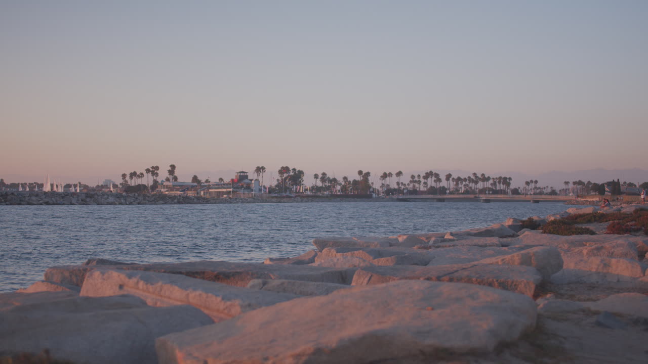바다 운하 바위에 주황색 태양