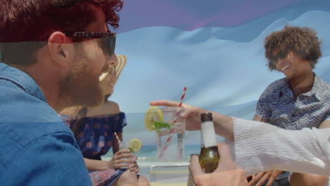 animación de ondear la bandera de los países bajos sobre un grupo de amigos que se divierten en la playa