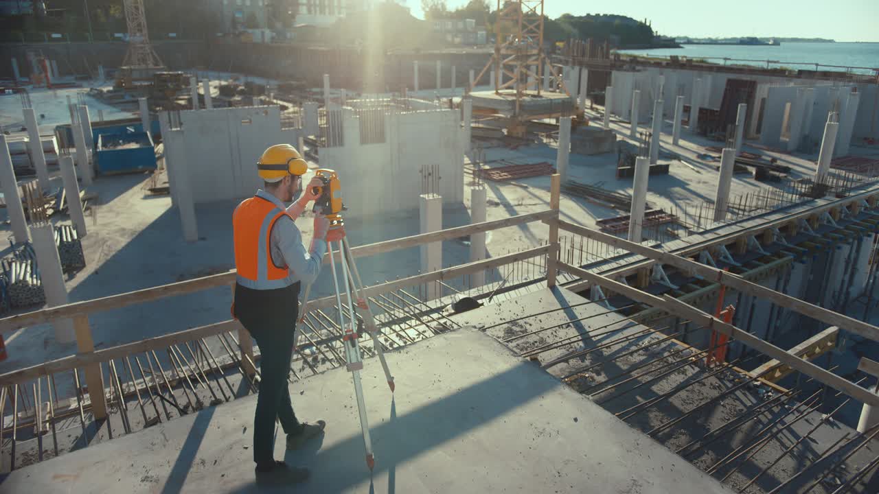 trabajador de la construcción que utiliza un instrumento óptico de topografía de teodolito para medir ángulos en planos horizontales y verticales en el sitio de construcción. trabajador con sombrero duro que hace proyecciones para el edificio.