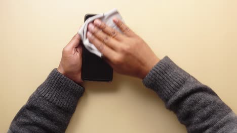 person cleaning their smartphone screen with a cloth