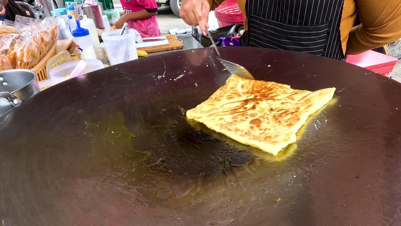Preparing Roti or Similar Flatbread on a Street Food Stall