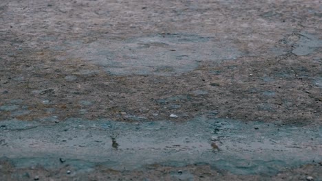 las gotas de lluvia caen sobre el pavimento formando un charco. lapso de tiempo