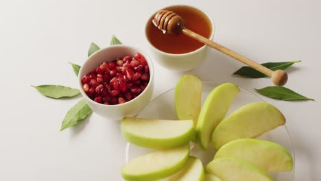 Video-of-honey-in-jar,-cranberries-and-apple-slices-lying-on-wooden-surface