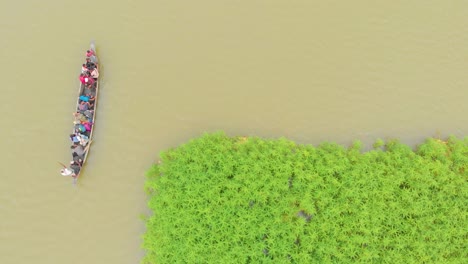 4k aerial top down shot of people in a row boat getting evacuated to land area in majuli river island submerged in the brahmaputra monsoon floods