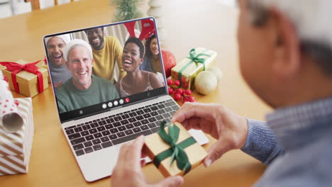 animation of biracial man in santa hat on laptop video call with family at christmas