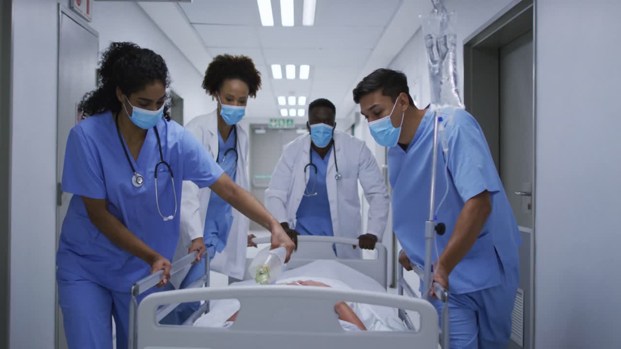 Medici di diverse etnie, uomini e donne, che indossano mascherine mentre trasportano un paziente.