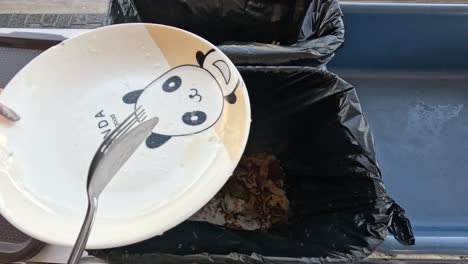 person discarding rice into a garbage can.