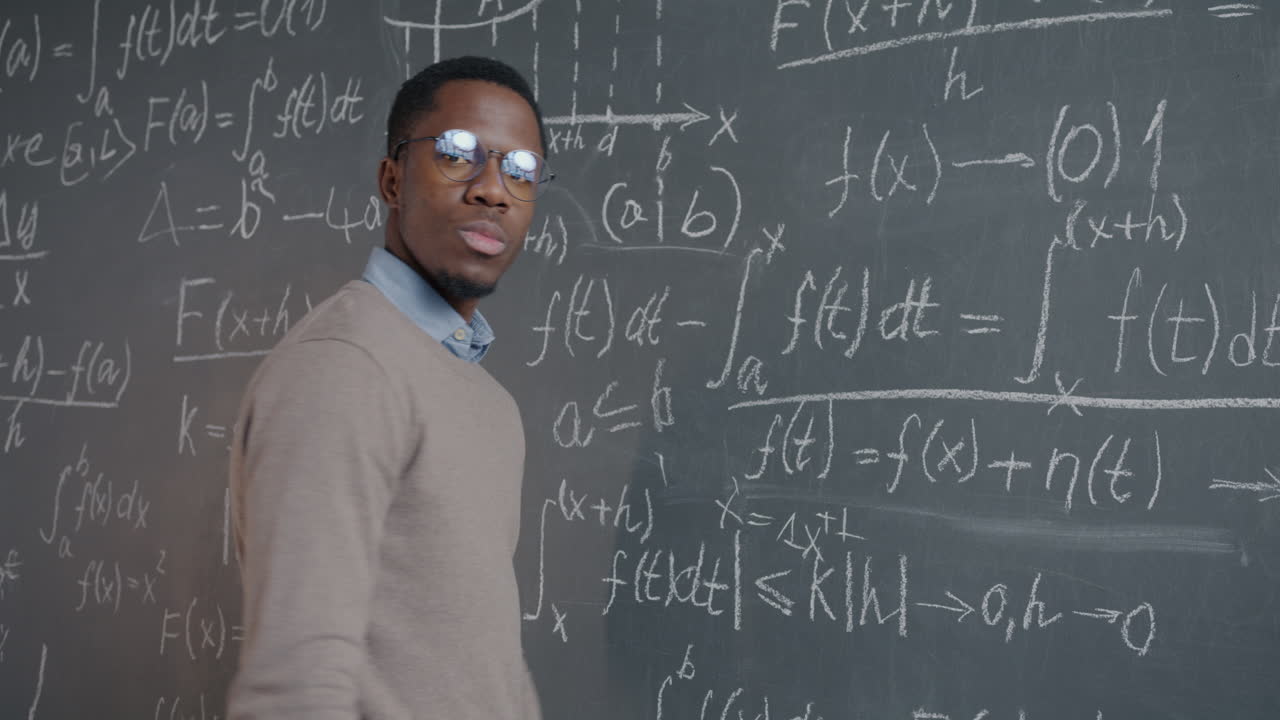 Man Writing Equations on a Chalkboard