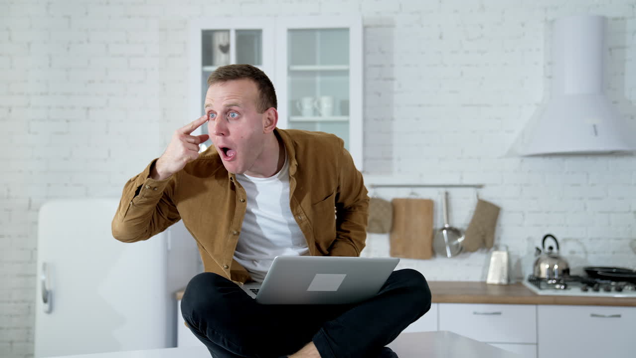 Funny man playing with his eye. Portrait of young adult amazed looking at camera.