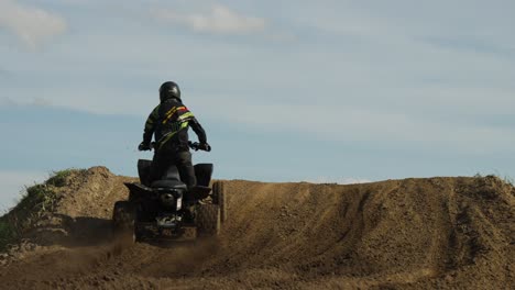 Una-Toma-Estática-De-Unos-Pocos-Ciclistas-Conduciendo-Quads-Sobre-Una-Colina-Arenosa-Del-Desierto-Por-La-Mañana-Desde-Atrás