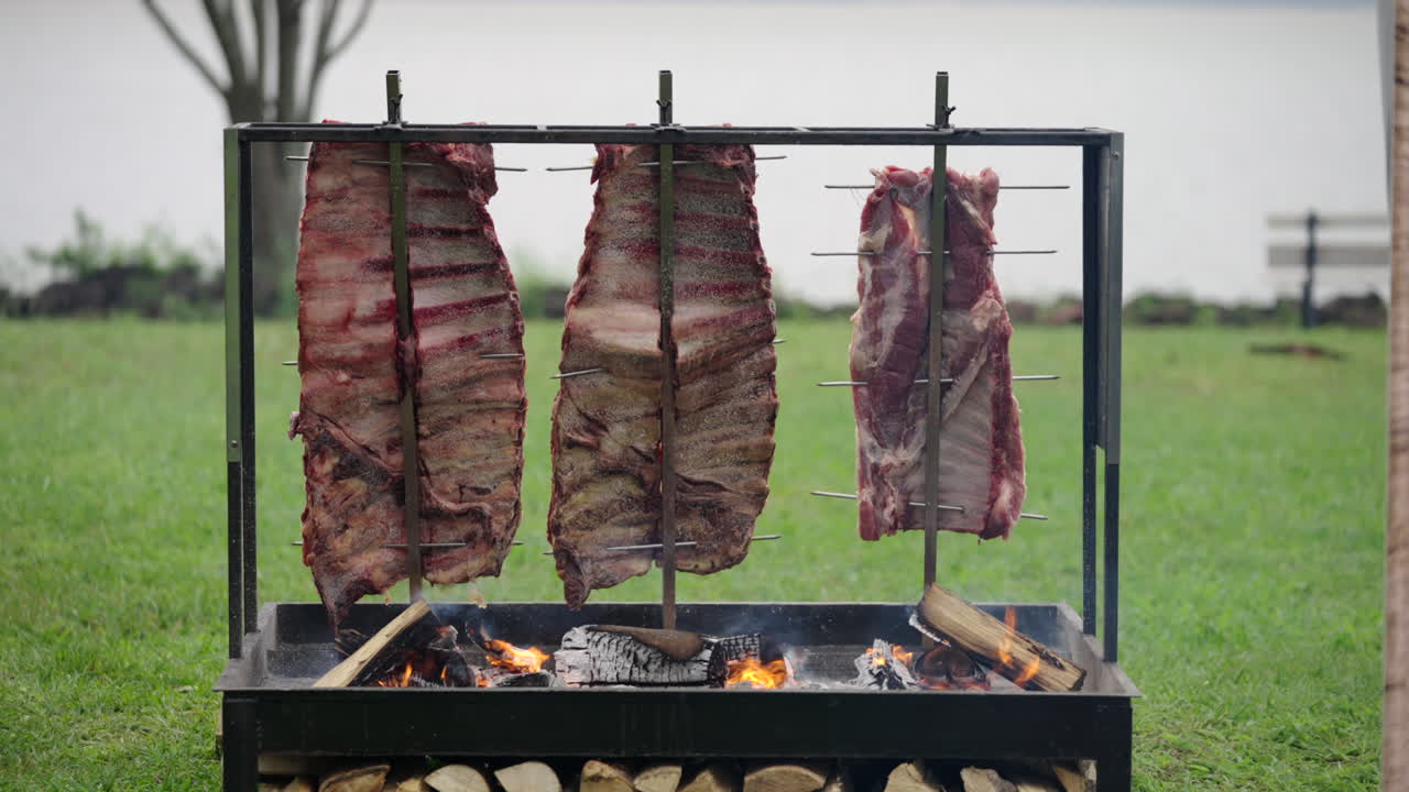 Authentic Argentinian barbecue scene with large meat cuts cooking on vertical grill, culinary latin lifestyle
