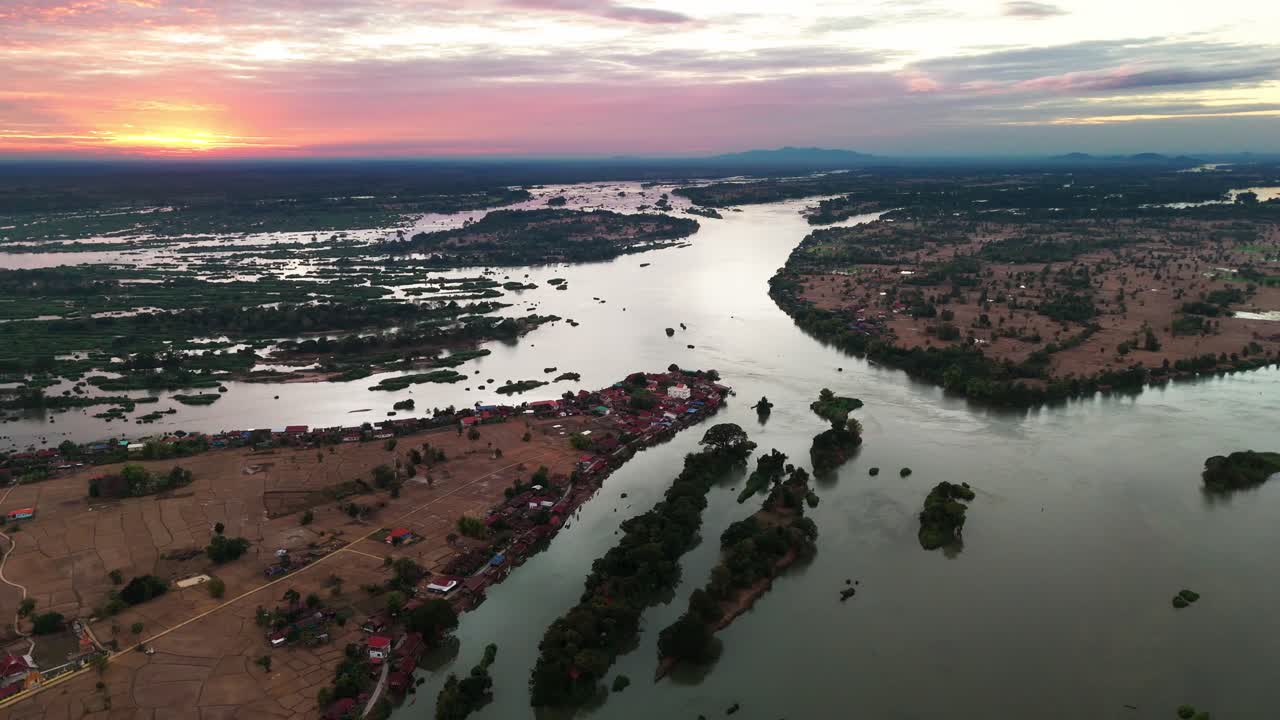 Water grassland flooded river at the Don Det area, aerial flight with view over the stunning land at sunset, sunrise at horizon