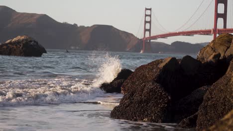 golden gate bridge, slow motion of pacific waves breaking on san francisco bay coast and baker beach