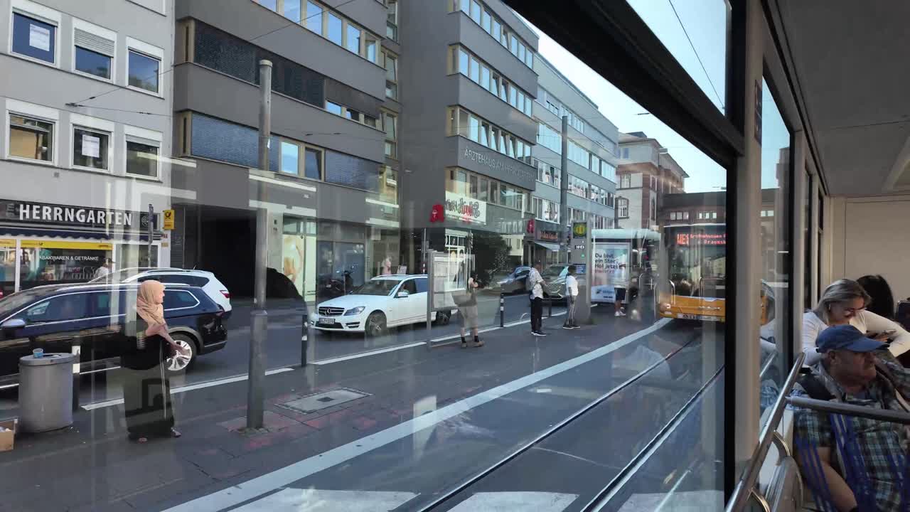 Riding a tram in Darmstadt, Hessen, Germany. People, street and bus stations.