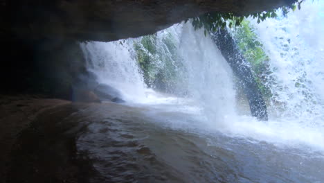 into a waterfall shot panning to showcase the falling water in slow motion in the jungle of chiang mai thailand asia in 4k downscaled to 1080p at 60fps