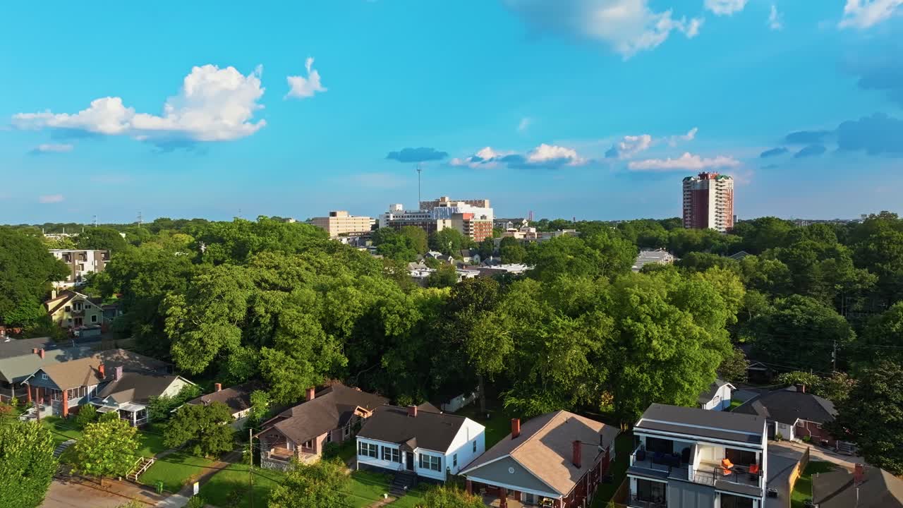 Condominium complex in central park neighbourhood surrounded by lush greenery, urban park under clear blue sky, Aerial view